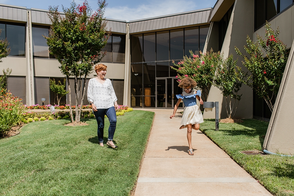 Women and girl walking on sidewalk