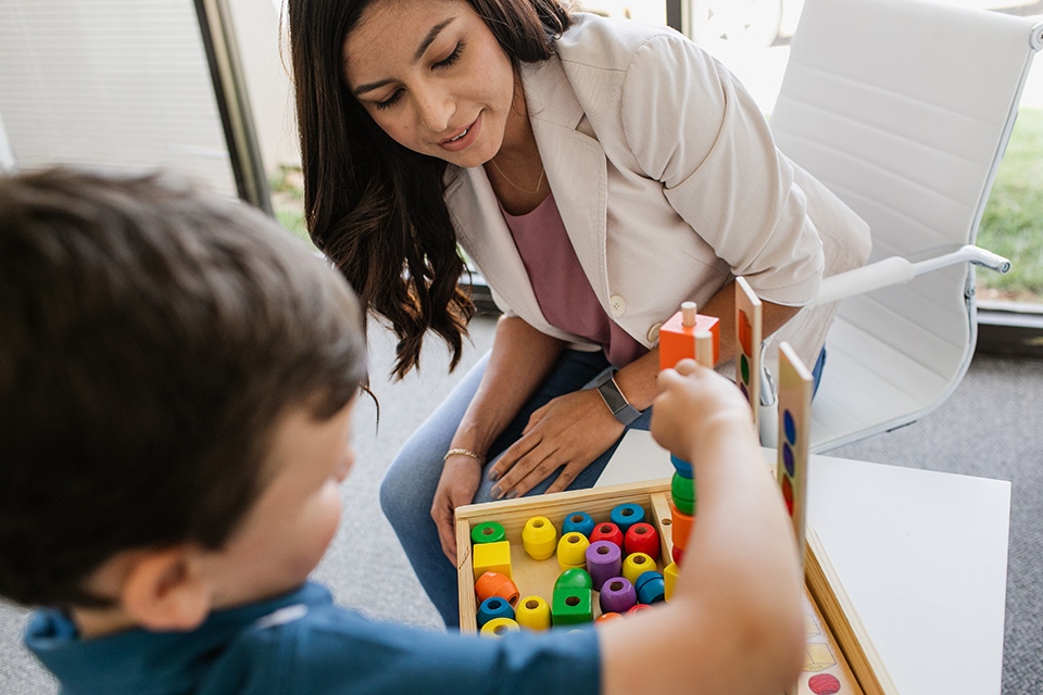 Woman watching child play